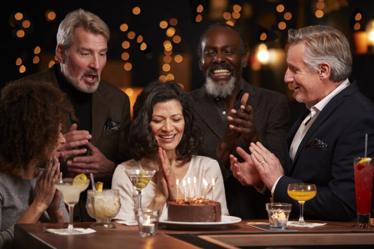 Group Of Middle Aged Friends Celebrating Birthday In Bar
